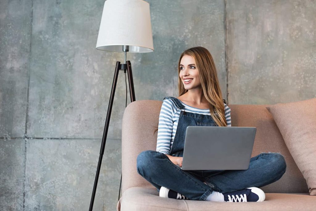 beautiful-woman-smiling-and-sitting-on-sofa-9540694